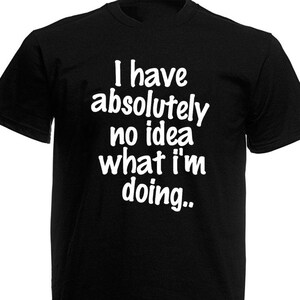 May include: Black t-shirt with the white text: "I have absolutely no idea what I'm doing..". The short-sleeved shirt is made of a soft material and is suitable for casual wear. The text is in a handwritten style font.