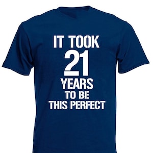 May include: A navy blue t-shirt with white text that reads "It took 21 years to be this perfect".