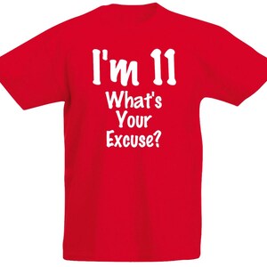 May include: A vibrant red t-shirt featuring the white text "I'm 11 What's Your Excuse?". The text is in a bold, clear font. The t-shirt is a standard crew neck design, suitable for everyday wear. The text is centered.
