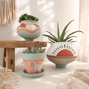 Vaso in cemento/terracotta dipinto a mano, vaso boho con motivo a sole, finitura opaca, colori terracotta pastello, forma organica, tonalità delicate, rotondo