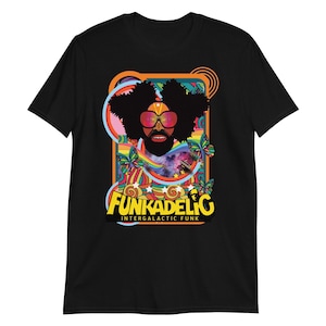 Może przedstawiać: Czarny t-shirt z kolorową grafiką przedstawiającą osobę z afro, okularami przeciwsłonecznymi i brodą. Grafika zawiera tęczę, motyle oraz napis "Funkadelic Intergalactic Funk" w kolorze żółtym i białym.