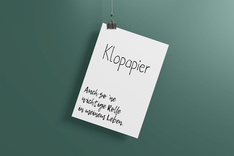 Puede incluir: Una hoja de papel blanca con el texto "Kloppapier" y "Auch so 'ne wichtige Rolle in meinem Leben." colgada de un clip sobre un fondo verde.