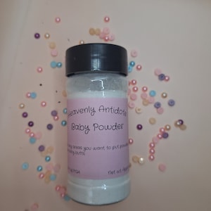 May include: A white plastic jar with a black lid containing baby powder. The label reads "Heavenly Antidote Baby Powder" and includes instructions for use. The jar is surrounded by colorful beads.