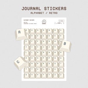 Könnte beinhalten: Ein Stickerbogen mit der Aufschrift JOURNAL STICKERS ALPHABET / RETRO zeigt ein Raster aus cremefarbenen, quadratischen Tastenkappen-Aufklebern mit dunkelgrauen Buchstaben. Drei größere, abgelöste Aufkleber mit A, B und C liegen um das Raster.