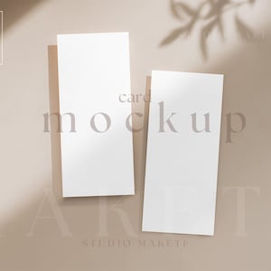 May include: Two blank white cards on a beige background with the text "card mockup" and "Studio Makete" printed on the background.