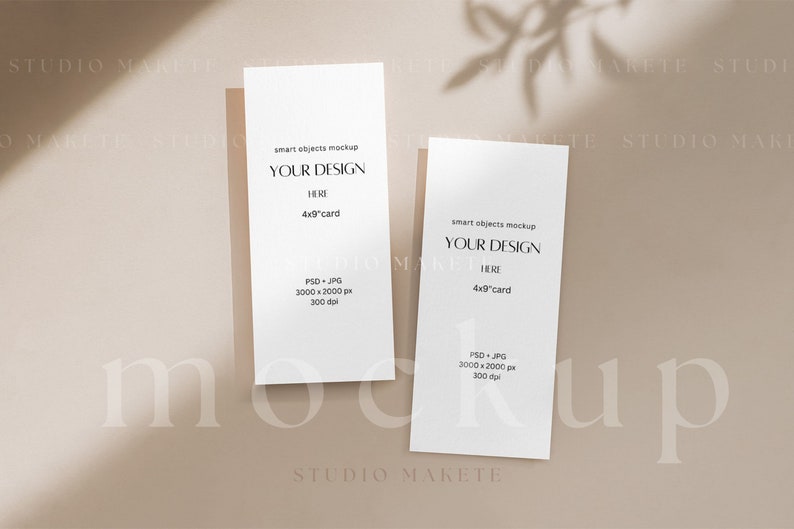 May include: Two white 4x9 inch cards with the text "smart objects mockup" and "YOUR DESIGN HERE" on a beige background. The cards are positioned vertically and are partially in the shadow of a plant.