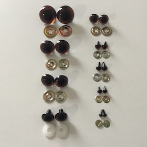 May include: Assortment of brown and black plastic safety eyes for crafts, with metal washers and plastic washers. The eyes come in various sizes.