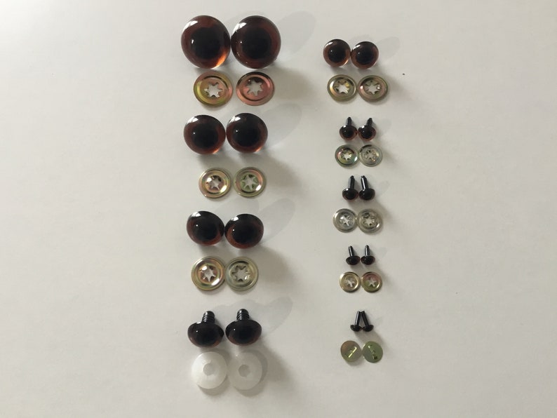 May include: Assortment of brown and black plastic safety eyes for crafts, with metal washers and plastic washers. The eyes come in various sizes.