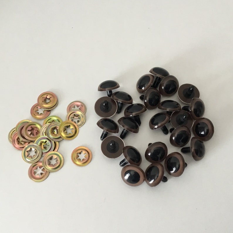 May include: A collection of brown plastic safety eyes with black pupils and metal washers for attaching to stuffed animals or crafts.