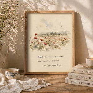 May include: A framed print featuring a watercolor landscape of a field of red poppies and a distant village. The print includes the quote, "Adopt the pace of nature; her secret is patience." A lit candle and books are nearby.