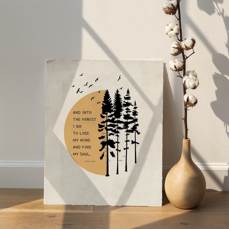 K&ouml;nnte beinhalten: Ein beiger Poster mit einer schwarzen Silhouette eines Waldes mit einem gelben Kreis dahinter. Der Text auf dem Poster lautet "AND INTO THE FOREST I GO TO LOSE MY MIND AND FIND MY SOUL." - JOHN MUIR