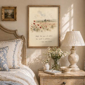 May include: A bedroom scene featuring a bed with a floral pillow and a framed print with a field of red poppies. A bedside table holds a lamp, a vase of flowers, and a small bowl. The print includes the quote: "Adopt the pace of nature, her secret is patience."