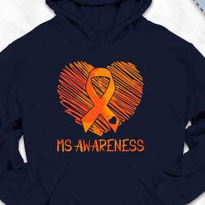May include: Navy blue hoodie with an orange heart-shaped design and an orange ribbon, with the words "MS AWARENESS" in orange. The hoodie is surrounded by accessories, including shoes, jeans, and a backpack.