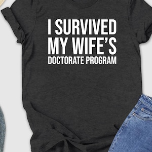 I Survived My Wife's Doctorate Program Shirt, Sarcastic Gift For PHD Husband, PHD Dissertation Tee, Funny PHD Graduation Gift, Husband Shirt