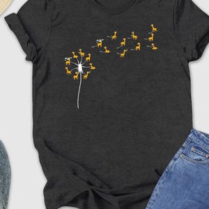 a t - shirt with a dandelion on it next to a pair of