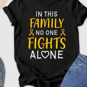 In This Family No One Fights Alone Shirt, Cancer Shirt, Gold Ribbon Shirt, Cancer Gifts, Fights Cancer Awareness Shirt, Cancer Support Shirt