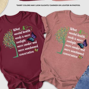May include: Two t-shirts, one maroon and one heather mauve, with the text "What mental health needs is more sunlight, more candor and more unashamed conversation." Each shirt features a tree design and a butterfly.