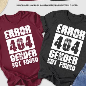 May include: Two t-shirts, one maroon and one dark grey heather, with the text "ERROR 404 GENDER NOT FOUND" in white. The shirts are displayed with accessories like sunglasses, a hat, and jeans.