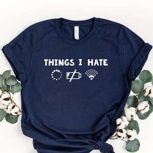 May include: A navy blue t-shirt with the text "Things I Hate" and three icons: a loading circle, a low battery icon, and a wifi signal icon.