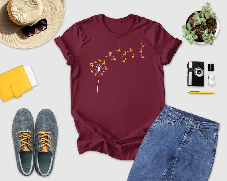 a t - shirt with a dandelion on it next to a pair of