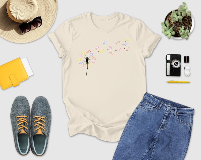 a t - shirt with a dandelion on it next to a pair of