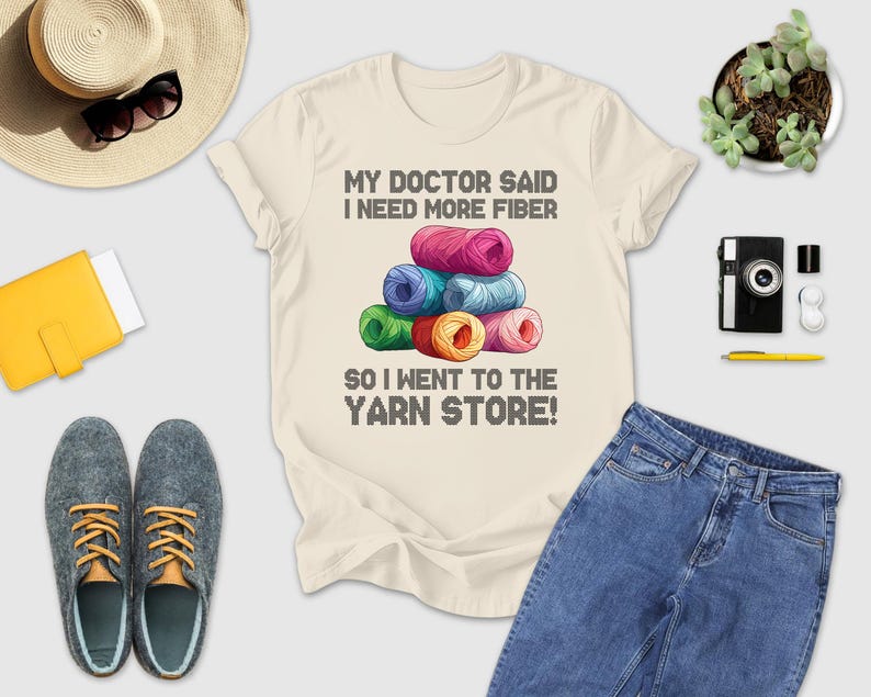 a casual outfit laid out on a white background, including a t-shirt with a humorous text, a hat, sunglasses, a camera, a wallet, a pair of shoes, and a potted plant.