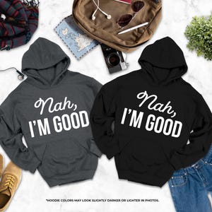 two hooded sweatshirts with the text " Nah, I'm good" printed on them, along with a pair of jeans, a pair of shoes, a backpack, and some other items.