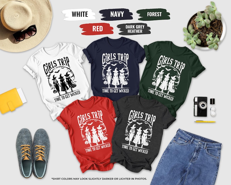 a collection of t-shirts with the phrase "Girls Trip" printed on them, along with various accessories such as sunglasses, a hat, a camera, and a plant.