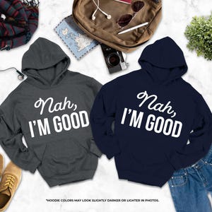 two hooded sweatshirts with the text " Nah, I'm good" printed on them, along with a pair of jeans and some other clothing items.