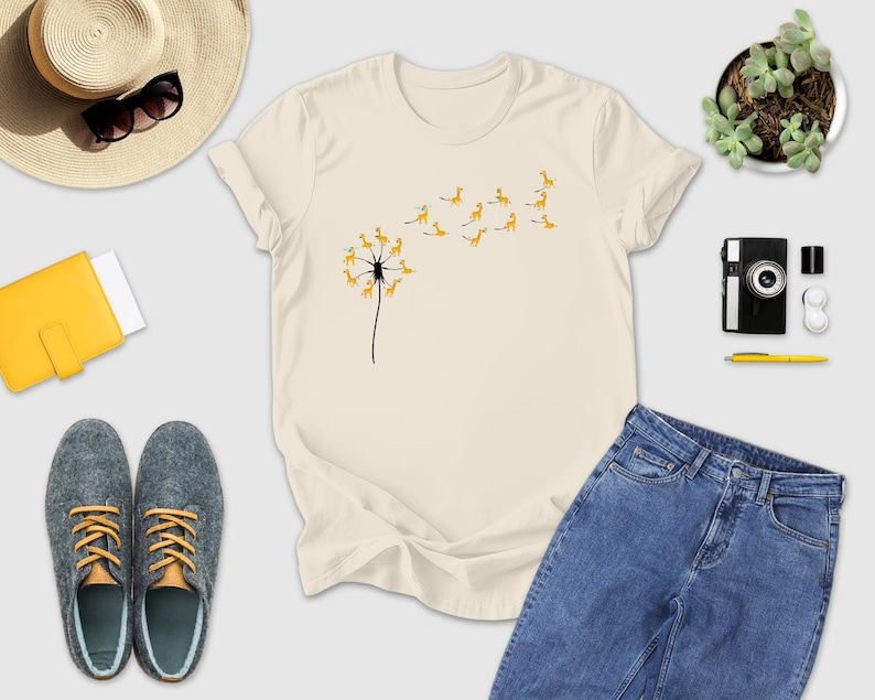 a t - shirt with a dandelion on it next to a pair of