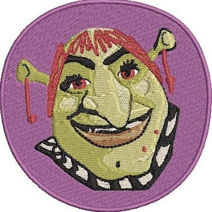 May include: Embroidered patch featuring a green ogre face with red hair and a black and white collar, set against a purple circular background. The ogre has a wide smile and red eyes. The patch is designed for application on clothing or accessories.