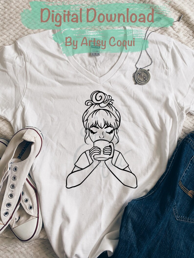 以下が含まれることがあります： 白いTシャツに、髪の毛をまとめた女性がマグカップから飲んでいる黒い線画が描かれています。Tシャツの上部には「Digital Download By Artsy Coqui」というテキストがあります。