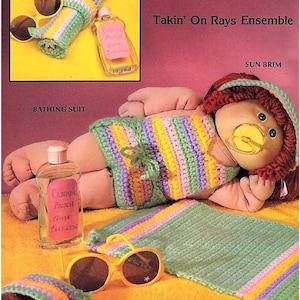 Puede incluir: Un conjunto de ganchillo con una muñeca en traje de baño a rayas, sombrero para el sol y toalla de playa. Los accesorios incluyen un bolso de toalla, gafas de sol y una botella de protector solar. La paleta de colores incluye verde, amarillo, morado y rosa.