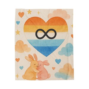 May include: A soft blanket featuring a heart-shaped design with orange, yellow, and blue stripes, and a black infinity symbol. Two hugging bunnies are at the bottom, with hearts, stars, and clouds scattered around. The blanket is a light beige color.
