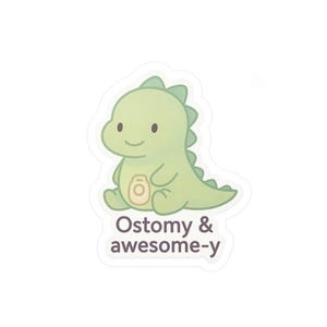 May include: A sticker featuring a light green dinosaur with a friendly expression. The dinosaur has a cream-colored belly and a row of spikes down its back. The text "Ostomy & awesome-y" is printed below the dinosaur in a dark brown color.
