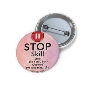 May include: A round button with a pink and white gradient background. The button features the word "STOP" in bold black letters, with "Skill" below it. Additional text includes "Stop, Take a step back, Observe, Proceed mindfully" and "KHcreations817".