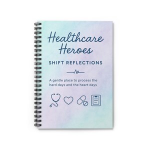 Könnte beinhalten: Ein spiralgebundenes Notizbuch mit einem Cover, auf dem in marineblauer Schrift "Healthcare Heroes" steht. Das Cover hat einen Aquarellhintergrund in Blau-, Lila- und Grüntönen. Das Notizbuch enthält medizinische Symbole und den Text "SHIFT REFLECTIONS".
