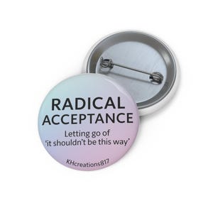 May include: Two round buttons with a pin back. One button has the words "RADICAL ACCEPTANCE" in black text on a pastel gradient background. The text "Letting go of 'it shouldn't be this way'" is below. The other button is silver.