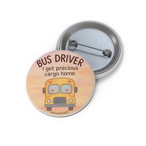 Puede incluir: Un botón redondo con el texto "BUS DRIVER" y "I get precious cargo home." presenta una ilustración de autobús escolar amarillo con ventanas en forma de corazón. El botón está sobre un fondo naranja claro.