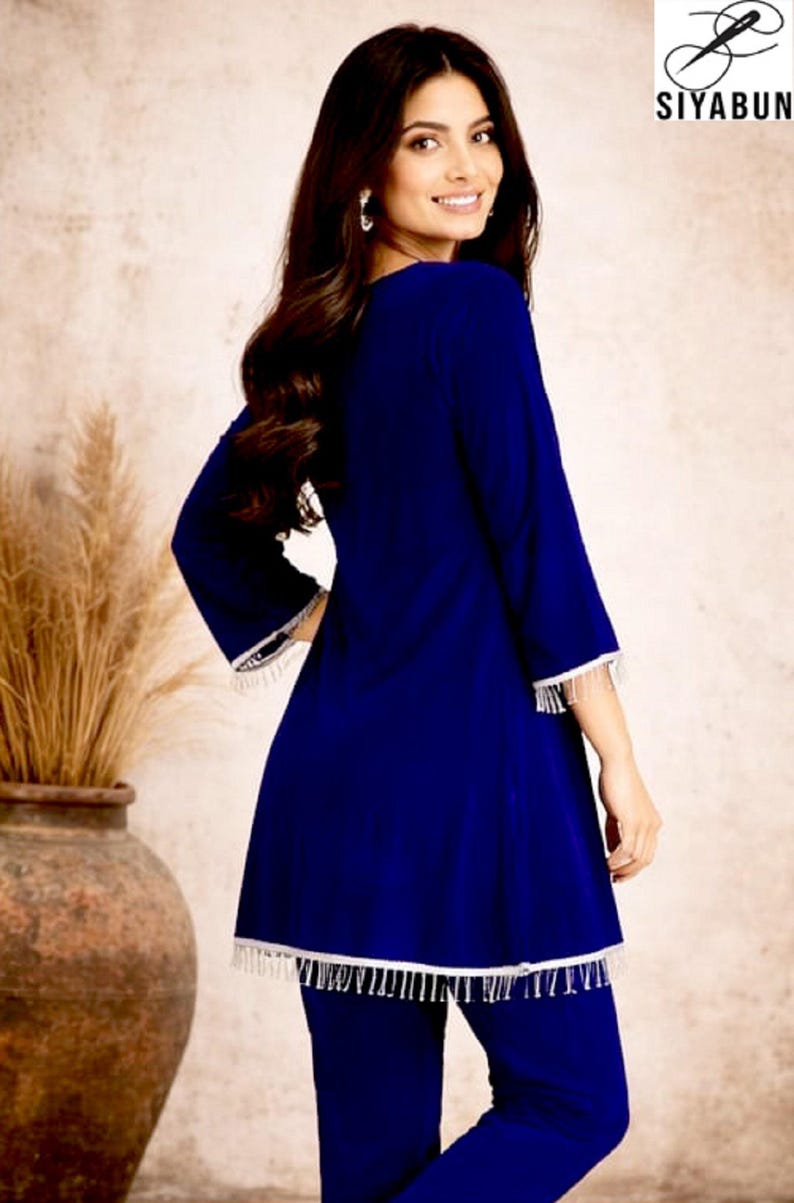 May include: A woman wearing a royal blue tunic and matching pants. The tunic has three-quarter sleeves and white fringe trim. The image includes the brand logo "SIYABUN" in the upper right corner.