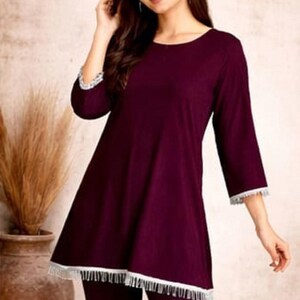 May include: Burgundy-colored pajama set. The top has a round neckline and three-quarter sleeves, trimmed with white lace. The matching pants complete the set. The image includes the brand logo "SIYABUN".