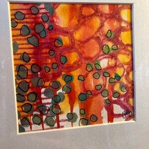 May include: Abstract watercolor painting with a mix of orange, red, yellow, and green colors. The painting features a pattern of circles and lines.