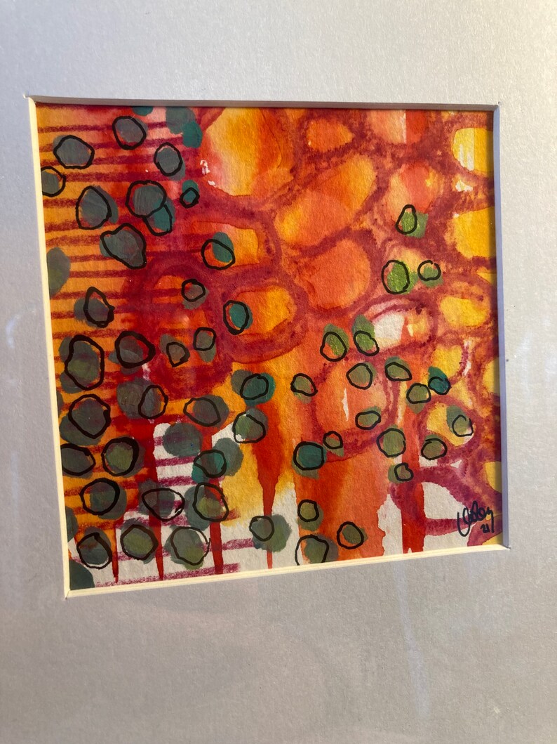 May include: Abstract watercolor painting with a mix of orange, red, yellow, and green colors. The painting features a pattern of circles and lines.