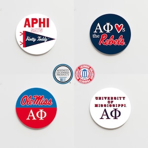 May include: Five round white stickers with red and blue text and designs. The stickers feature the text "APHI SAYS Hotty Toddy", "AΦ vs the Rebels", "Ole Miss AΦ", "UNIVERSITY OF MISSISSIPPI. AΦ", and a logo for the University of Mississippi.