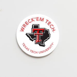 May include: A white circular button featuring the words "WRECK 'EM TECH" in red, with "TEXAS TECH UNIVERSITY" in red text. The button has a black and red logo of the state of Texas and the letters "TT".