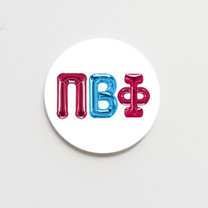 May include: A white round sticker with the letters "NB" in red and blue balloon letters and the symbol "&" in a red balloon letter.