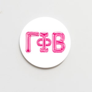 May include: A white round sticker with the letters "G*B" in pink balloon letters.