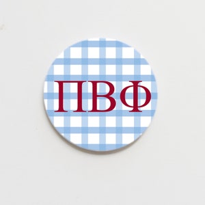 May include: A blue and white gingham patterned round coaster with the letters "ΠΒΦ" in red.