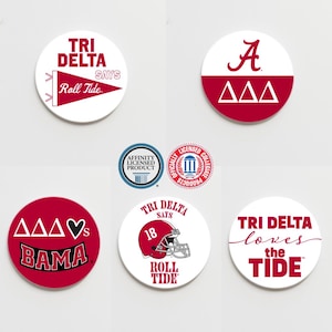 May include: Six round white stickers with red and black text and graphics. The stickers feature the text "Tri Delta" and the phrase "Roll Tide". One sticker has a heart and the text "Bama". Another sticker has the letter "A" and the text "AAA".