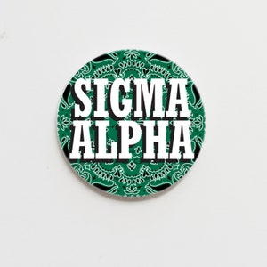 May include: A green and black patterned circle with the text "SIGMA ALPHA" in white.